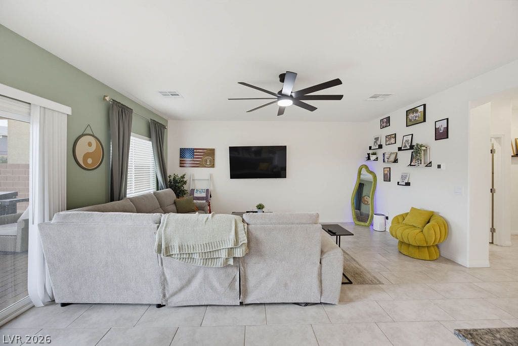 Sliding glass doors open from the tiled living space directly to the backyard.