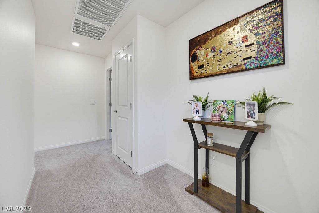 Plush carpeted flooring and neutral walls define this quiet upper-level hallway space.