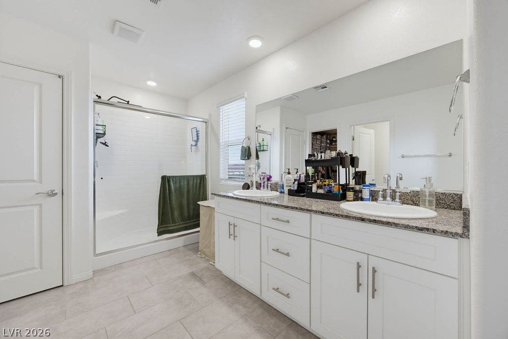 A spacious vanity with stone countertops highlights this master bathroom design.