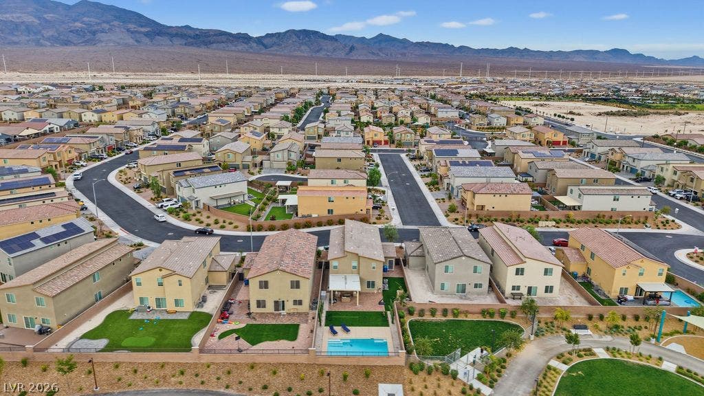An aerial perspective showcases a neat desert neighborhood set against a backdrop of rugged mountain peaks.