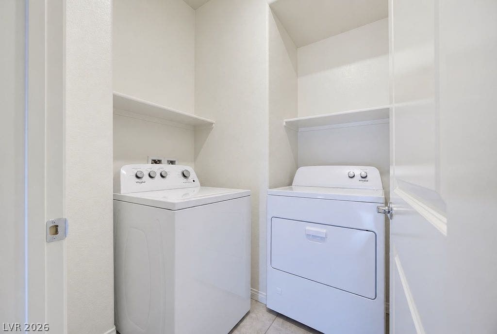Functional utility space features built-in overhead shelving and durable tile flooring.