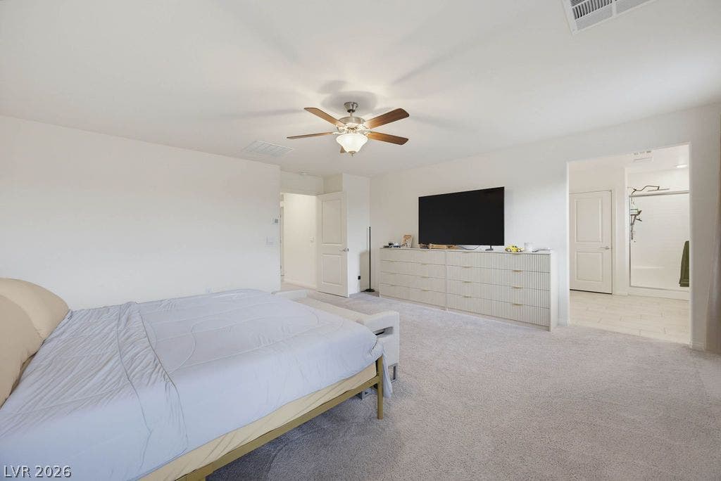 Plush carpet and smooth plaster walls define this serene primary suite with an ensuite bath.
