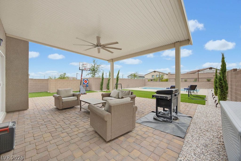 A spacious covered patio paved in brick transitions seamlessly to the open backyard and pool.