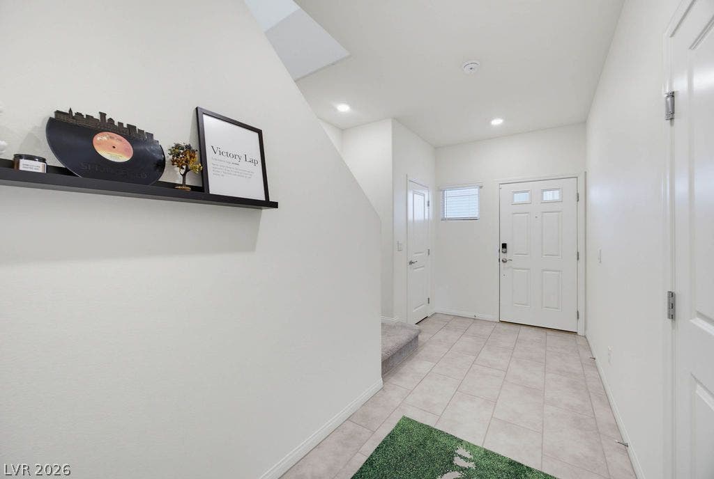 Crisp white walls and clean tile flooring define this welcoming home entryway.