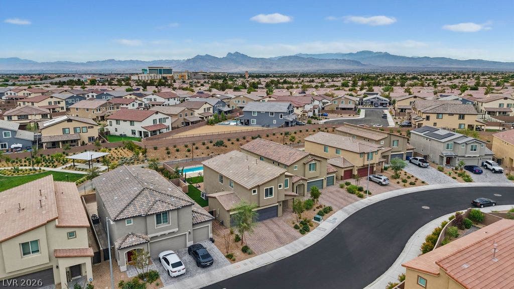 A quiet suburban neighborhood rests against a backdrop of majestic mountain ridges.