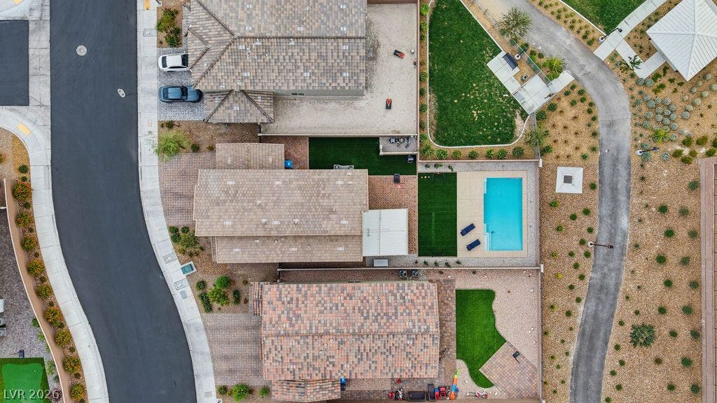 An aerial view highlights the tiled rooflines, manicured yards, and private swimming pool.