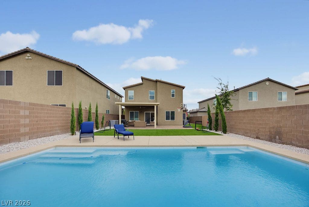 An inviting backyard oasis showcases a pristine swimming pool surrounded by clean concrete decking.