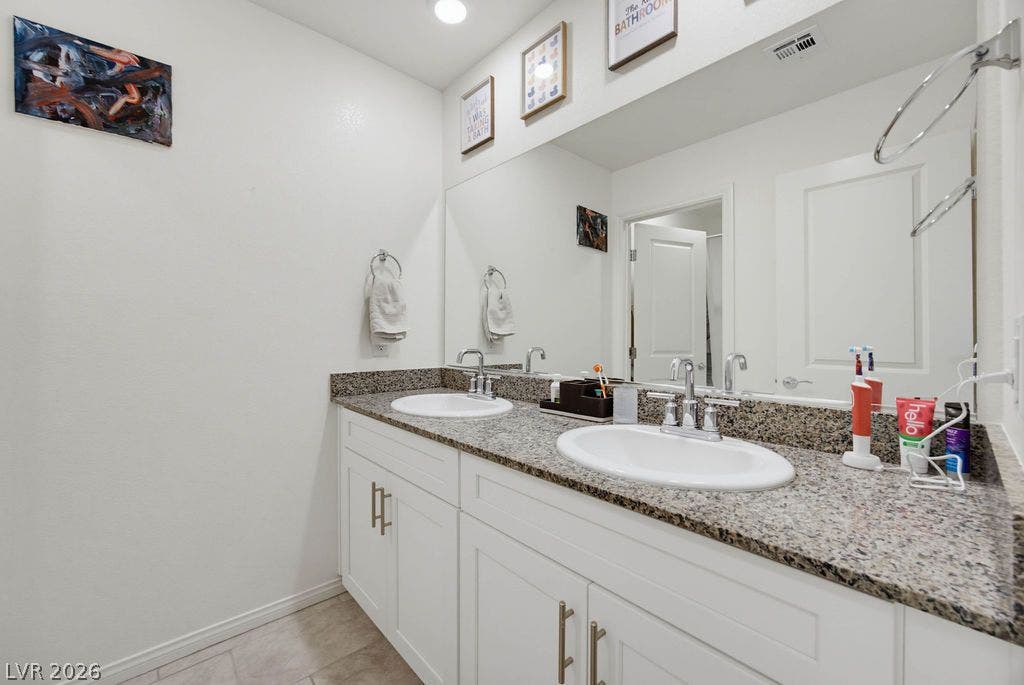 Granite counters and dual sinks elevate this modern bathroom design.