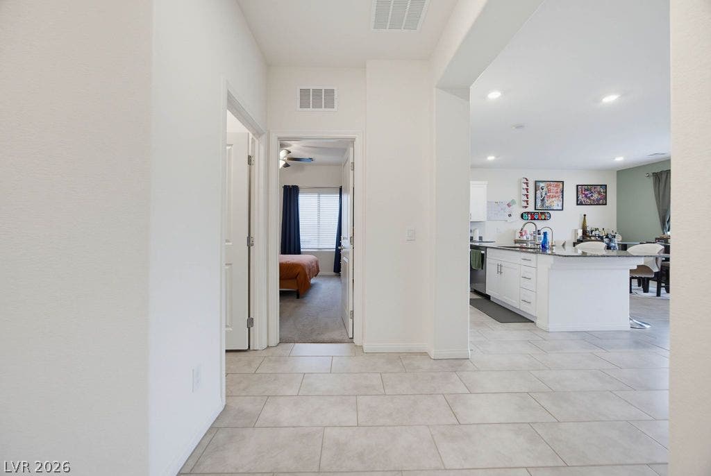 Tiled flooring flows through a central hallway connecting the kitchen and bedrooms.