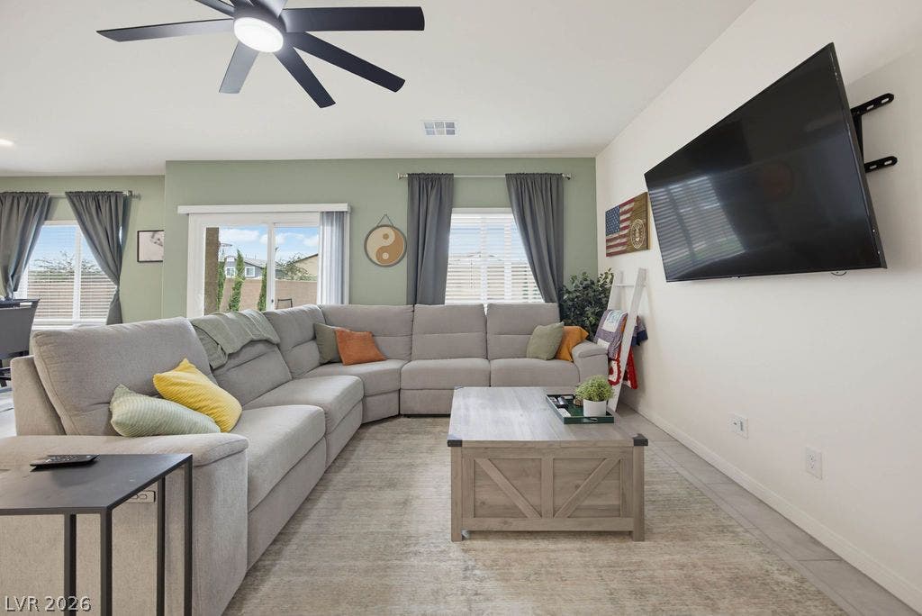 An open layout connects the living spaces under high ceilings and tile floors.