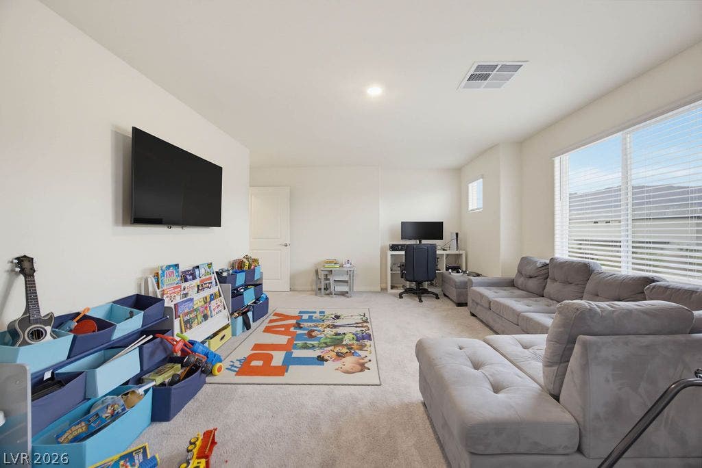 A spacious secondary living space features plush neutral carpeting and large windows offering neighborhood views.