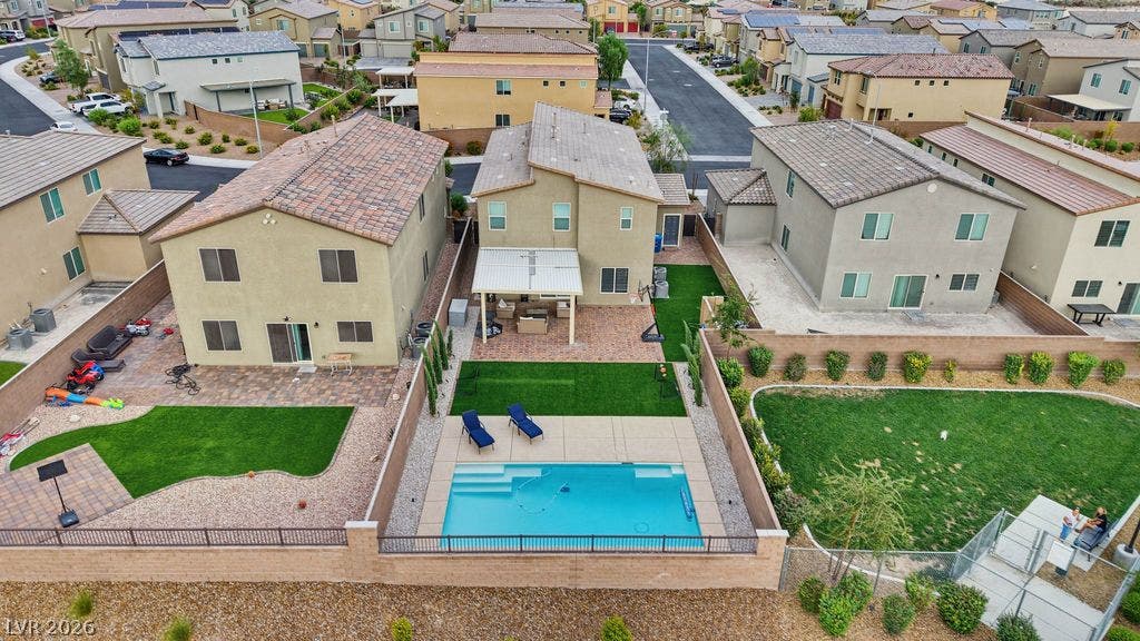A sparkling in-ground pool serves as the centerpiece of this landscaped suburban backyard.