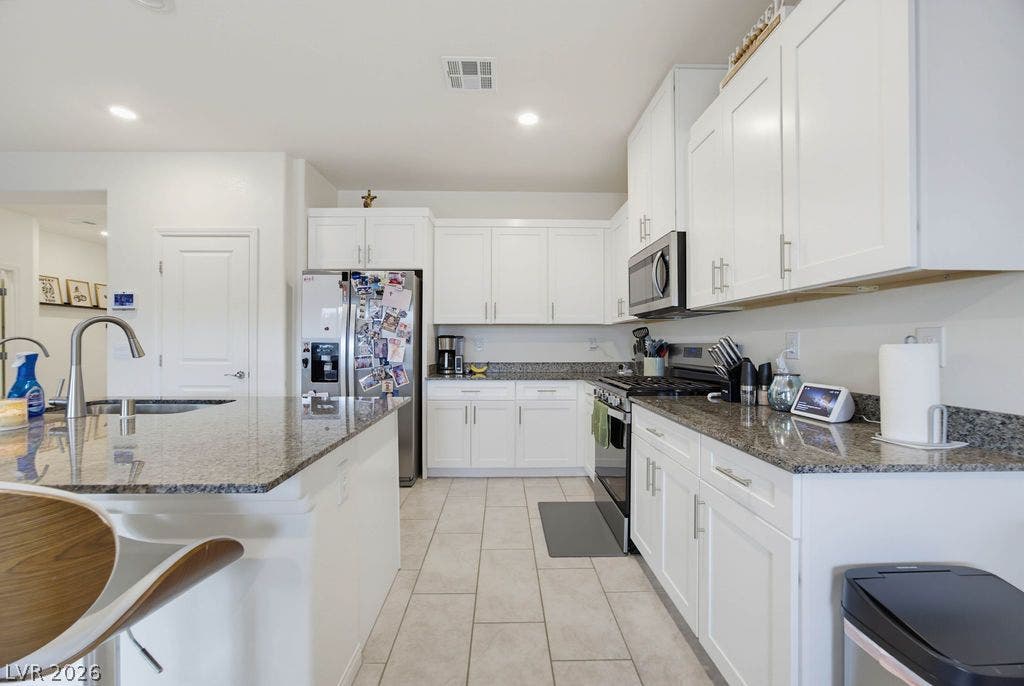 Polished granite countertops pair elegantly with classic white cabinetry in this functional workspace.