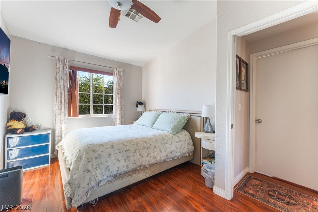 5330 E Charleston Boulevard, #123, Las Vegas, NV 89142 Gleaming hardwood floors run throughout this cozy bedroom featuring a view of mature greenery.