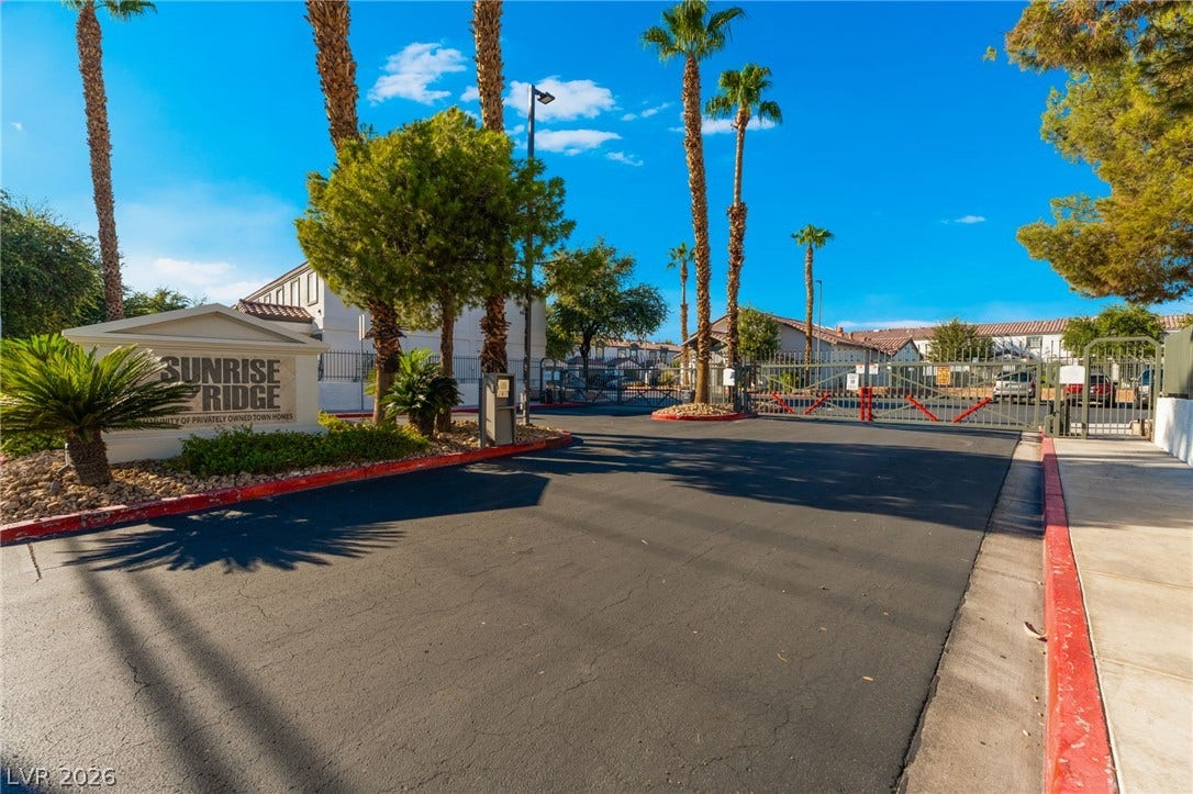 5330 E Charleston Boulevard, #123, Las Vegas, NV 89142 Secure gated entry features a paved driveway lined by palm trees and manicured plantings.