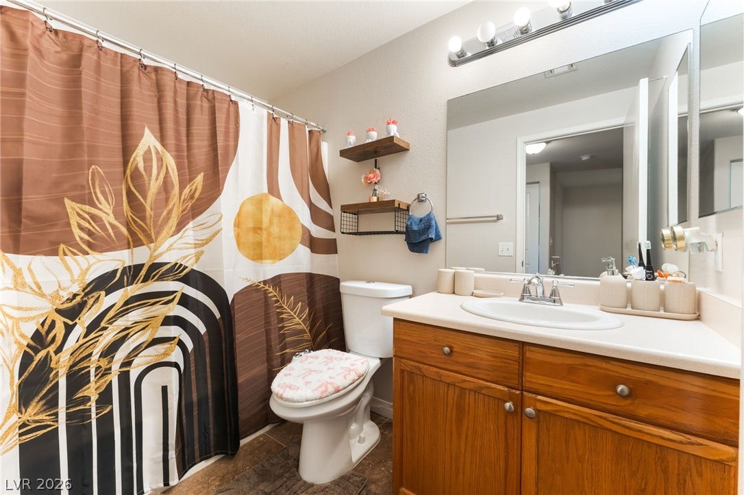 5330 E Charleston Boulevard, #123, Las Vegas, NV 89142 A classic wood vanity and a neutral solid countertop anchor this full bathroom.