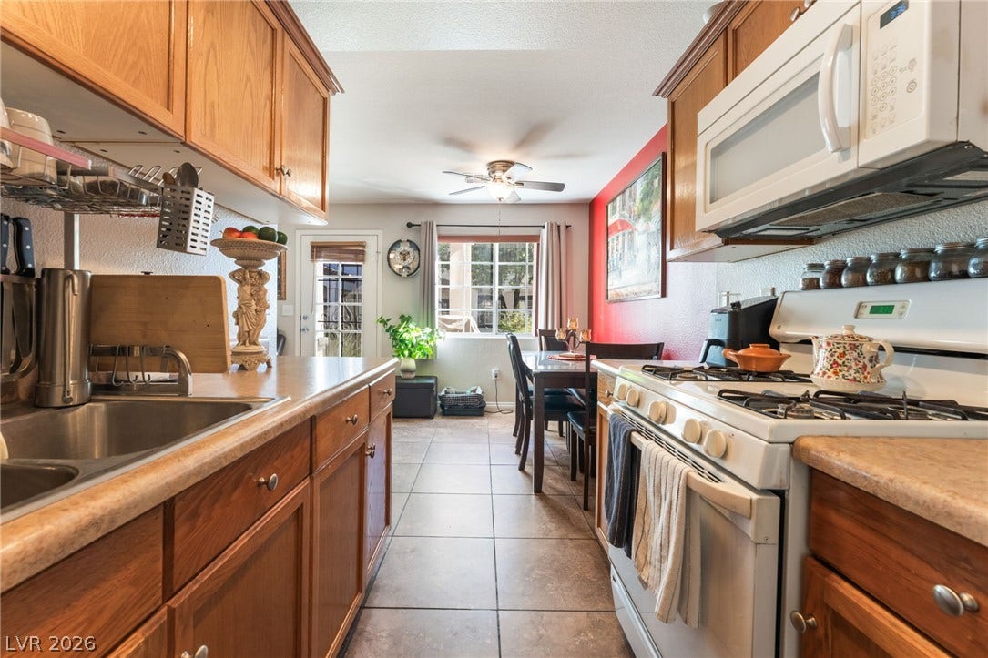 5330 E Charleston Boulevard, #123, Las Vegas, NV 89142 Rich wood cabinetry and tile flooring anchor this functional kitchen and adjoining dining area.