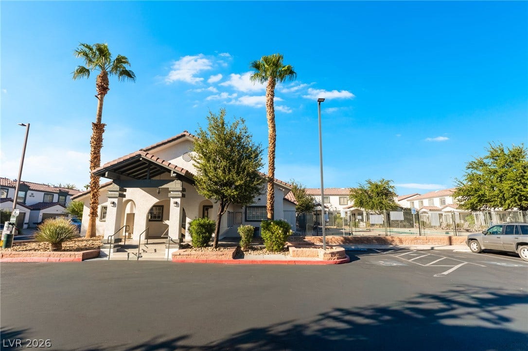 5330 E Charleston Boulevard, #123, Las Vegas, NV 89142 A welcoming clubhouse entrance features tiled roofing and manicured desert landscaping under clear blue skies.