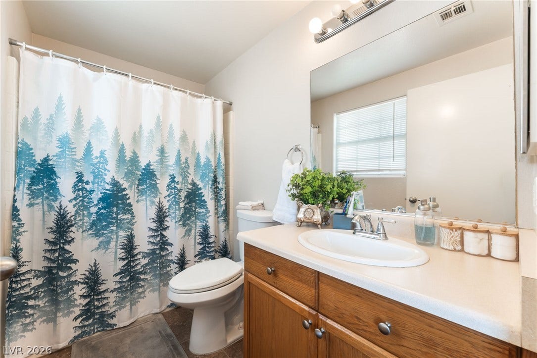 5330 E Charleston Boulevard, #123, Las Vegas, NV 89142 A spacious vanity with wood cabinetry sits opposite the shower and tub combination.