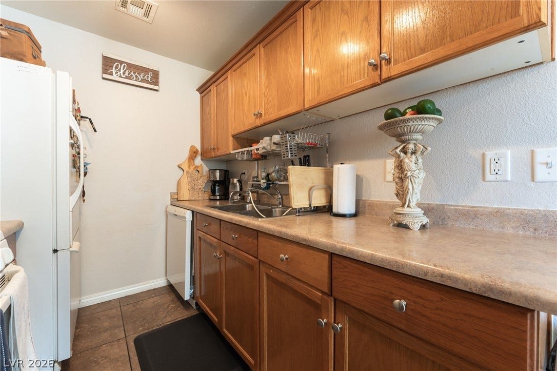 5330 E Charleston Boulevard, #123, Las Vegas, NV 89142 Ample wooden cabinetry and durable countertops define this functional, efficient kitchen workspace.