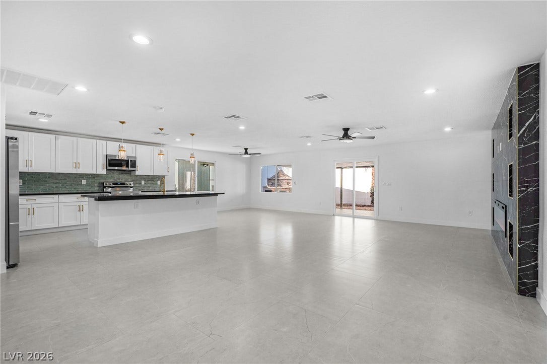 An open floorplan seamlessly connects the modern kitchen with the expansive living area.