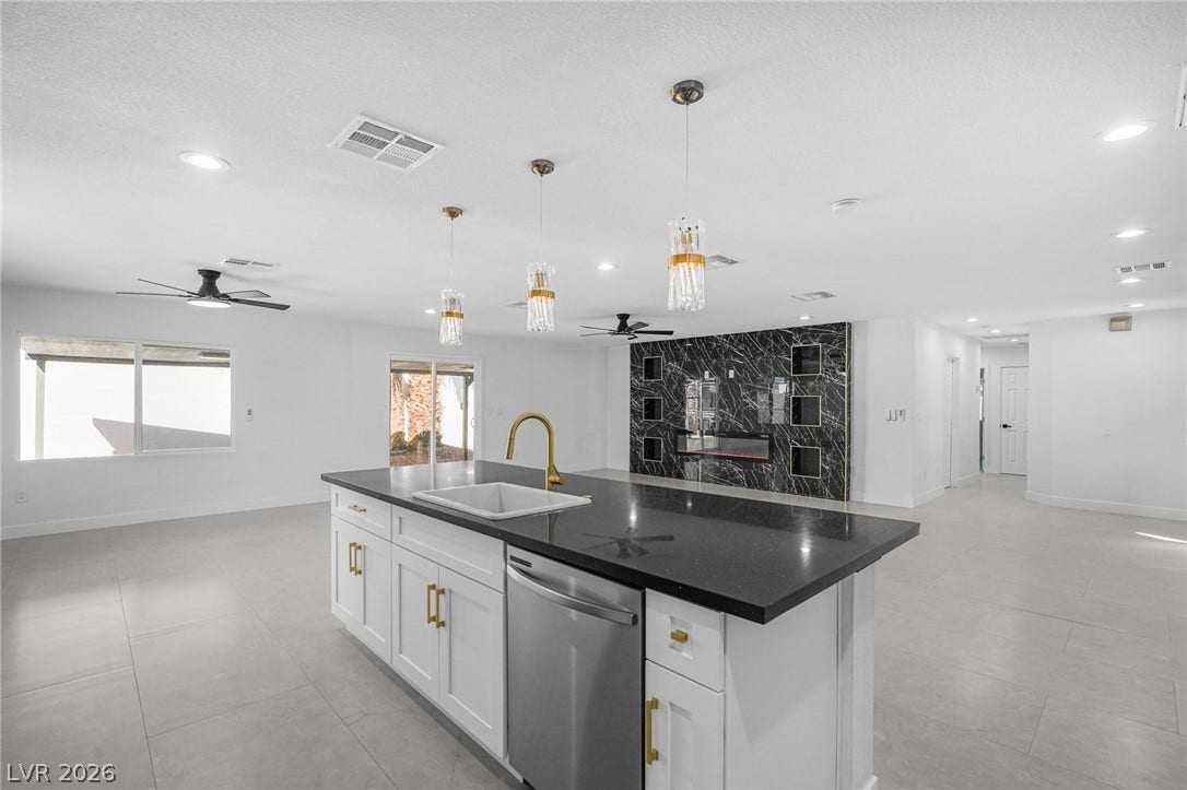 An open floor plan connects the kitchen to the living space with sleek tile flooring.