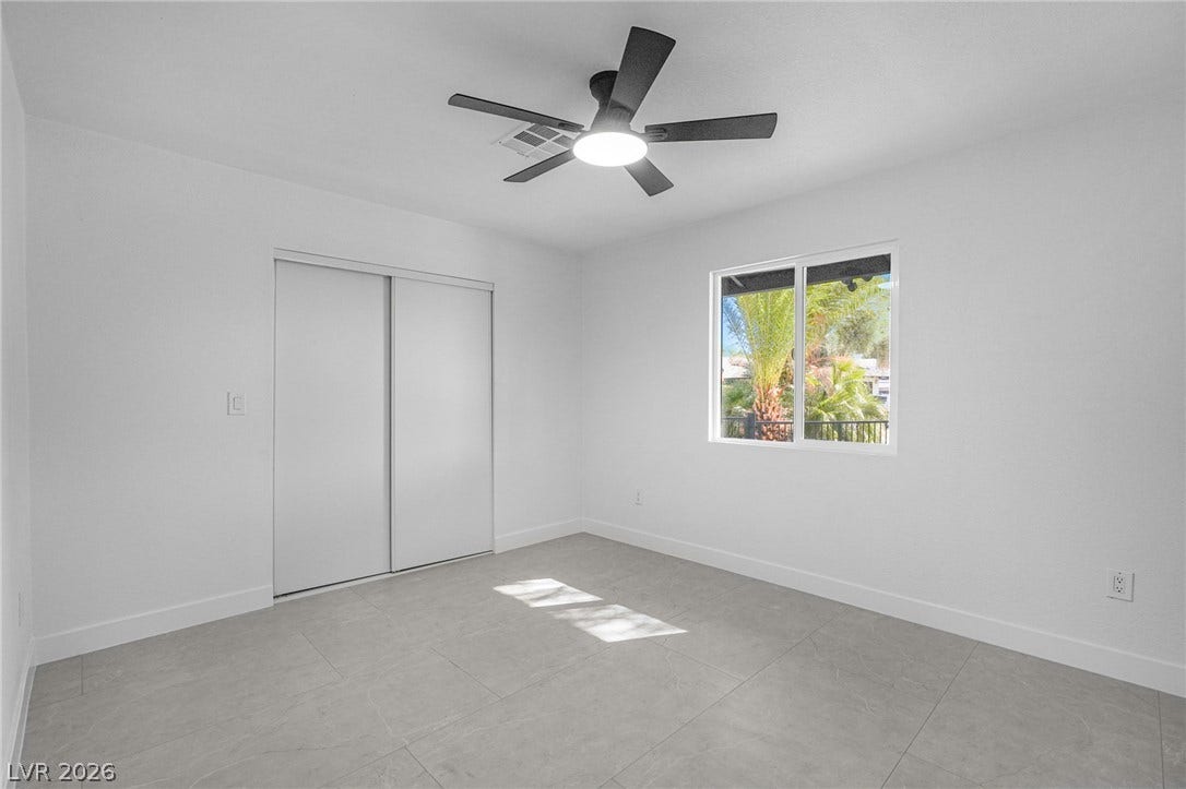 Clean lines and stone tile flooring define this quiet, light-filled bedroom retreat.