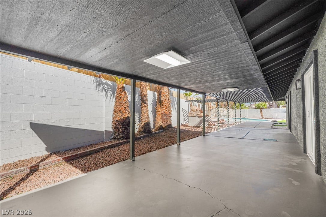 An extensive covered patio provides a shaded outdoor space alongside the home.