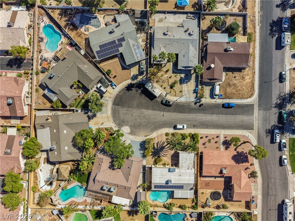 A top-down aerial perspective reveals a quiet suburban cul-de-sac surrounded by residential properties.