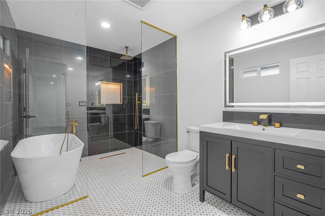 Modern finishes define this space featuring a sleek vanity and a separate soaking tub.