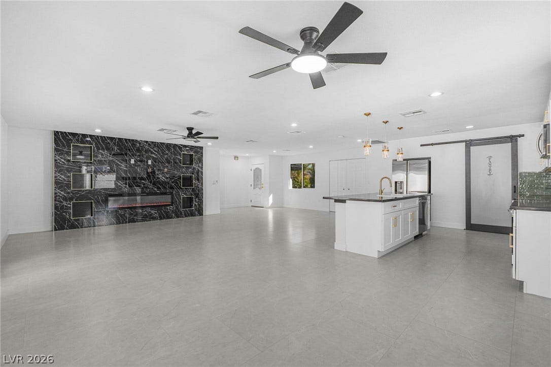Gleaming tile floors stretch across a sweeping open layout punctuated by a dramatic focal wall.