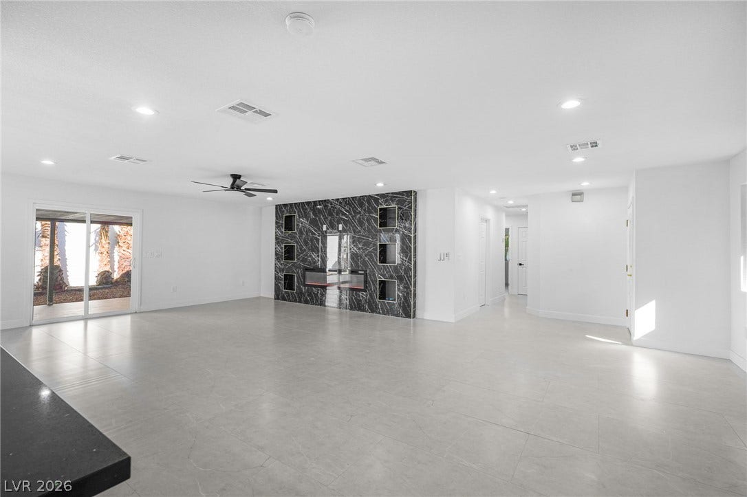 An open layout highlights a tiled floor and a sleek stone feature wall.