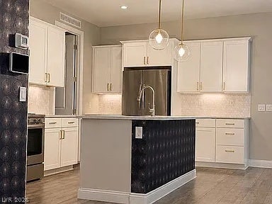 2126 Albury Avenue, North Las Vegas, NV 89086 Gleaming wood flooring complements crisp white cabinetry and a modern center island with sink.