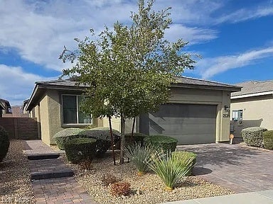 2126 Albury Avenue, North Las Vegas, NV 89086 Manicured desert landscaping frames the paved driveway leading to a modern two-car garage.