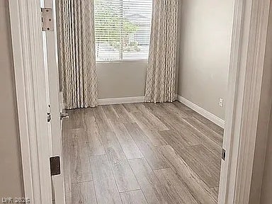 2126 Albury Avenue, North Las Vegas, NV 89086 Plank flooring and crown molding frame this versatile secondary bedroom or home office space.