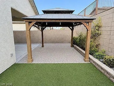 2126 Albury Avenue, North Las Vegas, NV 89086 A sturdy wooden gazebo shades a neatly paved patio alongside a low stone retaining wall.