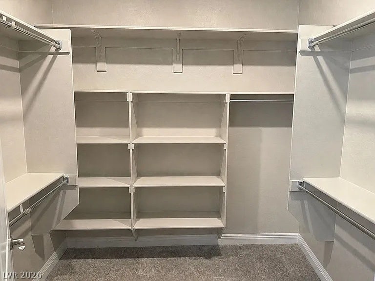 2126 Albury Avenue, North Las Vegas, NV 89086 A spacious walk-in closet includes custom built-in shelving, hanging rods, and soft carpeting.