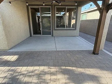 2126 Albury Avenue, North Las Vegas, NV 89086 An inviting covered patio features concrete and paver flooring alongside stucco exterior walls.