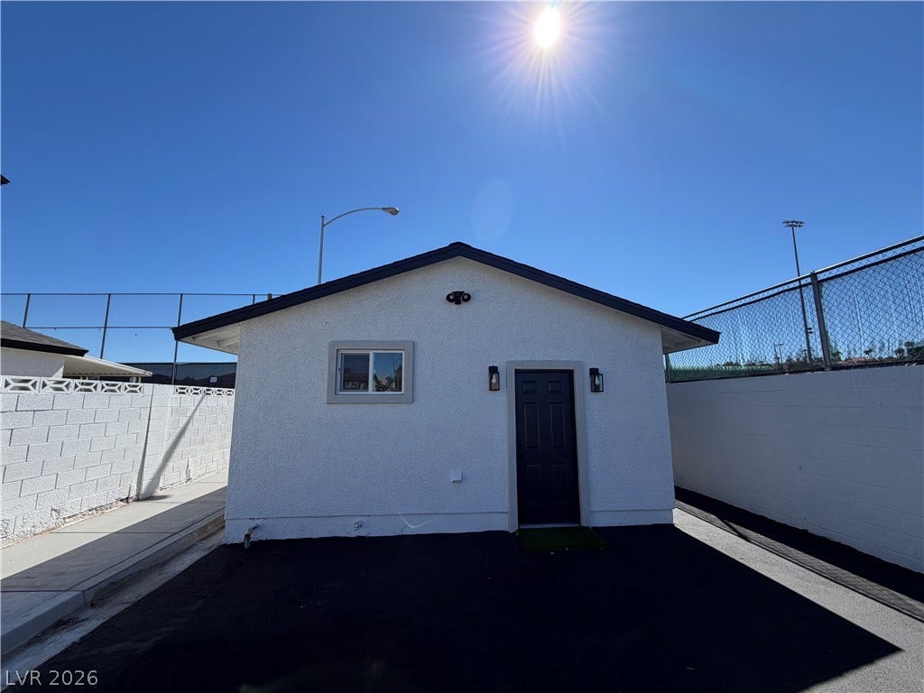 500 Grimsby Avenue, Henderson, NV 89014 A detached stucco structure stands under clear skies next to a private paved driveway.