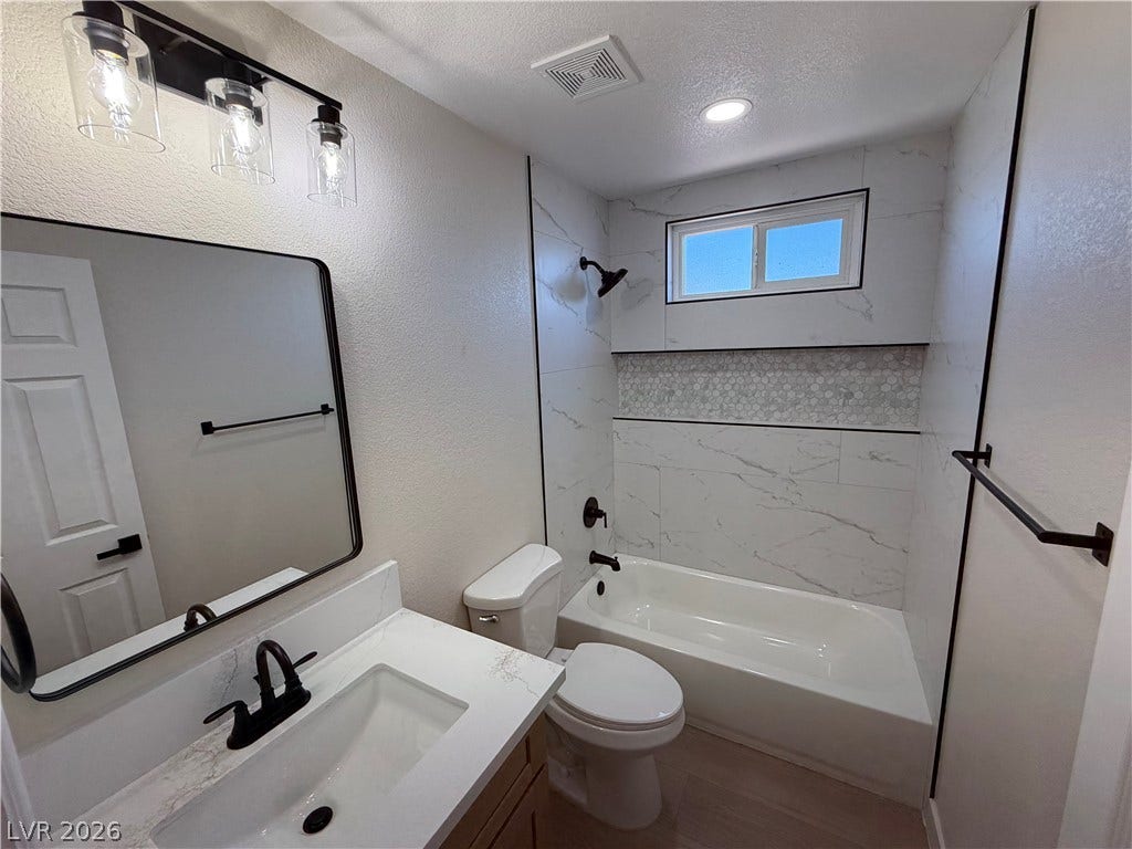 500 Grimsby Avenue, Henderson, NV 89014 Crisp stone counters and elegant modern tilework highlight this beautifully refreshed bathroom space.