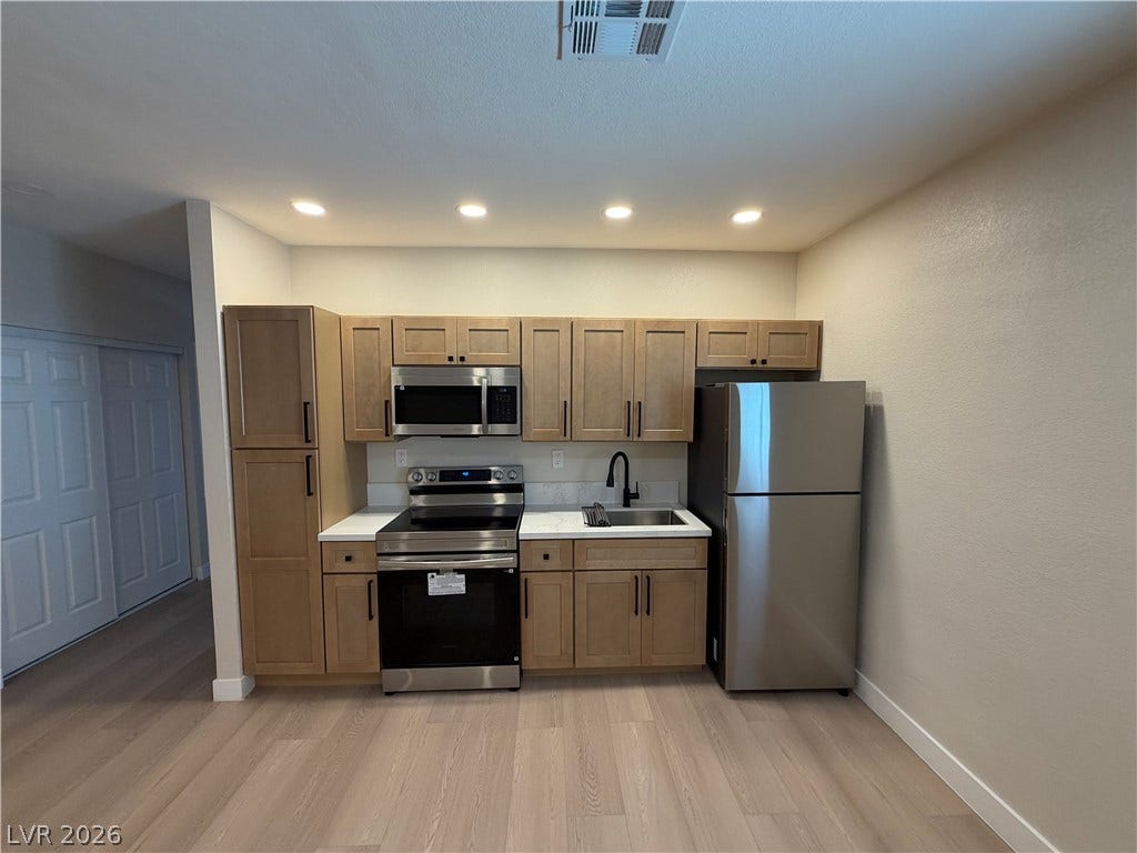 500 Grimsby Avenue, Henderson, NV 89014 Modern cabinetry and recessed lighting complement the sleek hard surface flooring in this kitchen.