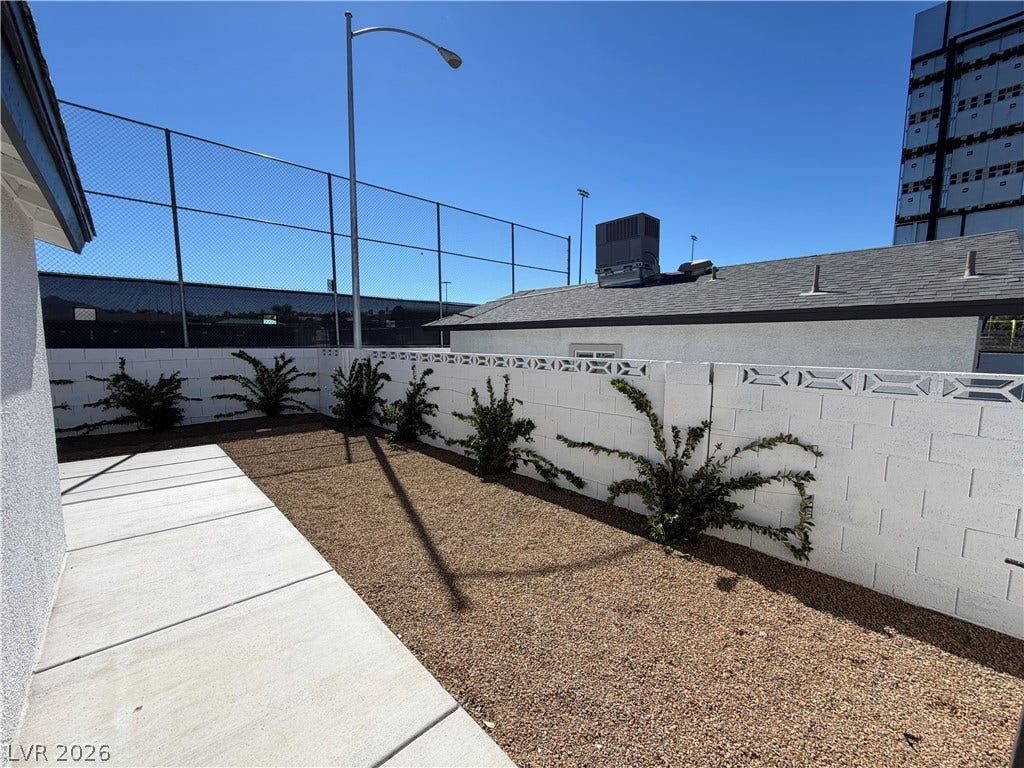 500 Grimsby Avenue, Henderson, NV 89014 A neat concrete walkway borders a low-maintenance gravel yard enclosed by a block privacy wall.