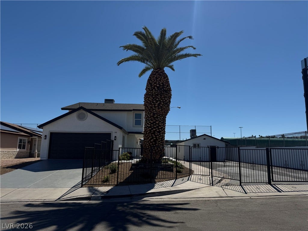 500 Grimsby Avenue, Henderson, NV 89014 An asphalt driveway leads to the attached two-car garage under a clear blue sky.
