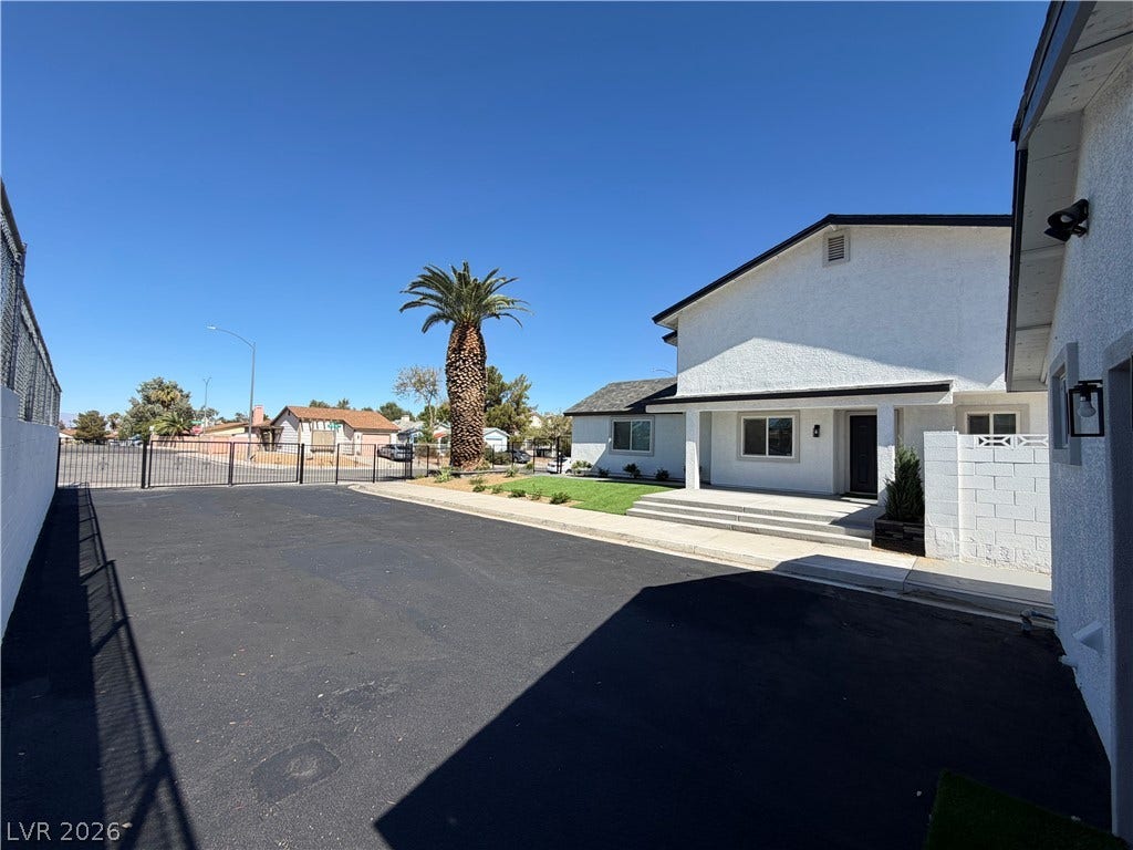 500 Grimsby Avenue, Henderson, NV 89014 An expansive asphalt driveway leads toward the modern stucco exterior under clear blue skies.