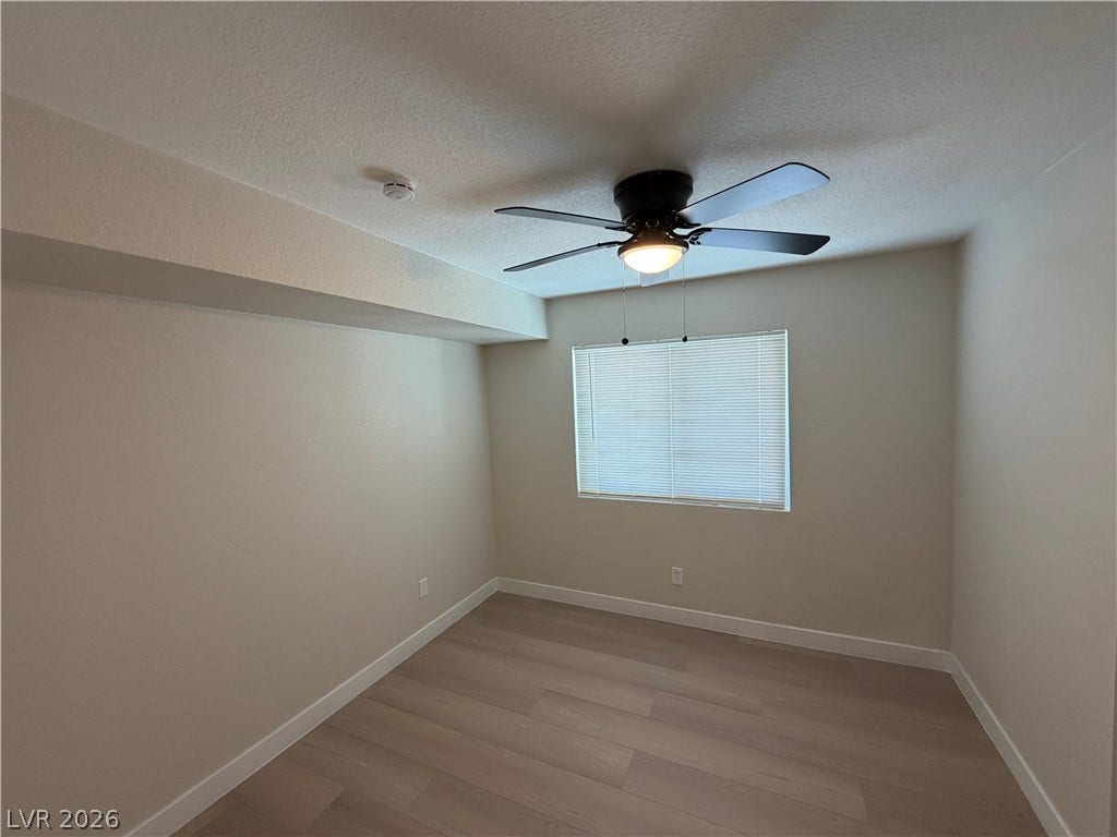 500 Grimsby Avenue, Henderson, NV 89014 Smooth wood-style flooring and a wide window define this minimalist interior space.