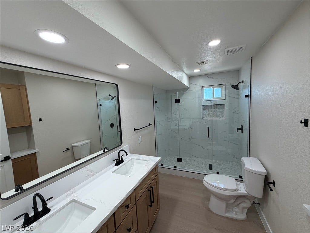 500 Grimsby Avenue, Henderson, NV 89014 Modern finishes define this bathroom highlighting a double vanity and a glass-enclosed shower.