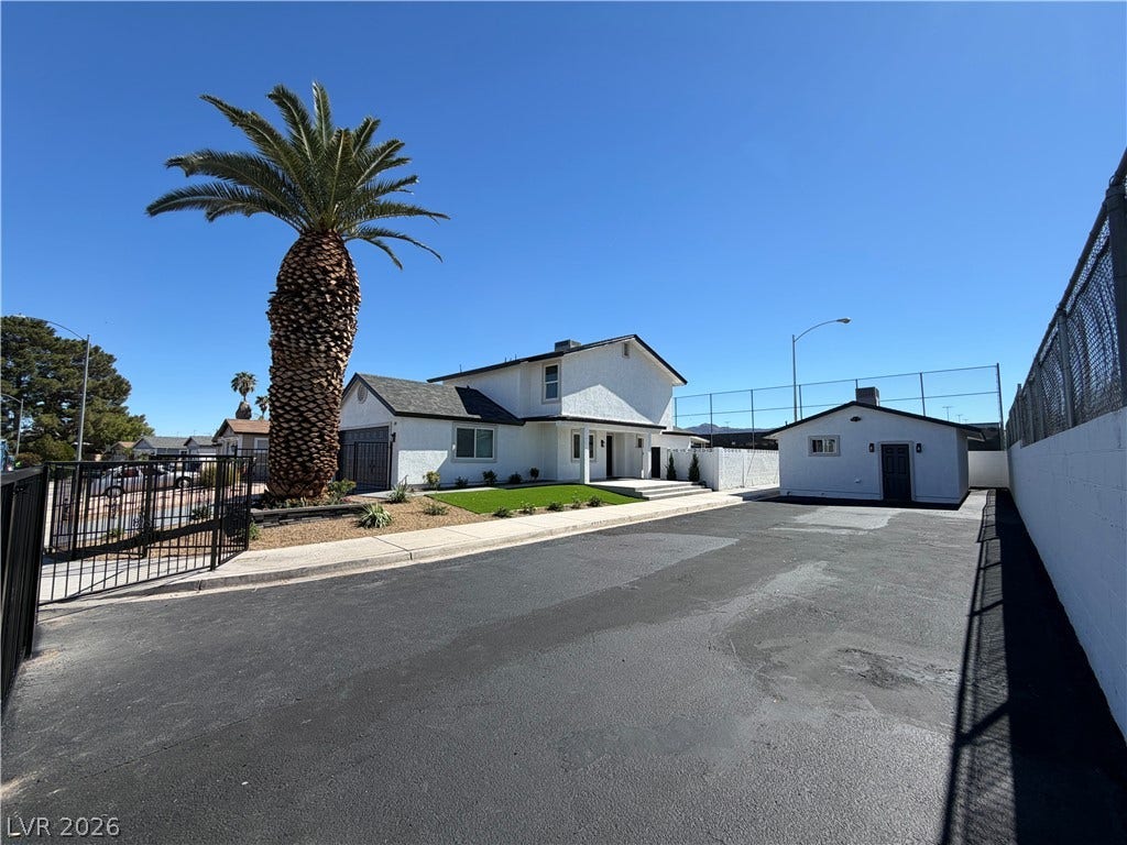 500 Grimsby Avenue, Henderson, NV 89014 A spacious paved driveway leads past a mature palm tree toward the multi-level residence.