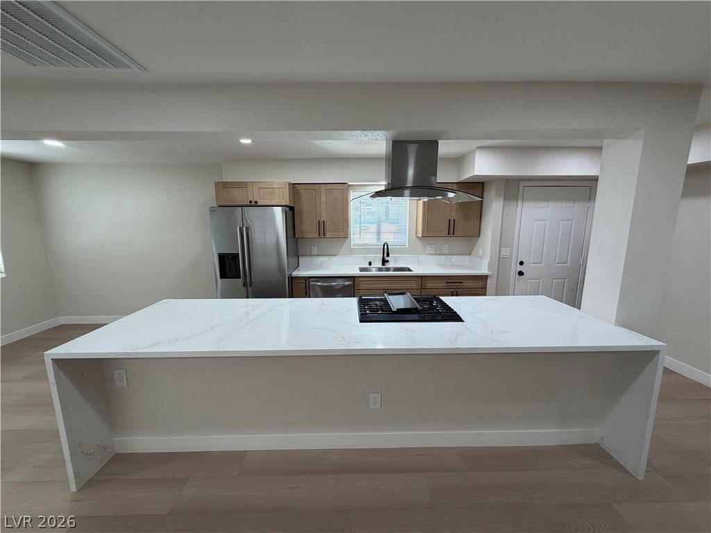 500 Grimsby Avenue, Henderson, NV 89014 An expansive waterfall island anchoring a modern kitchen with sleek countertops and stainless steel appliances.