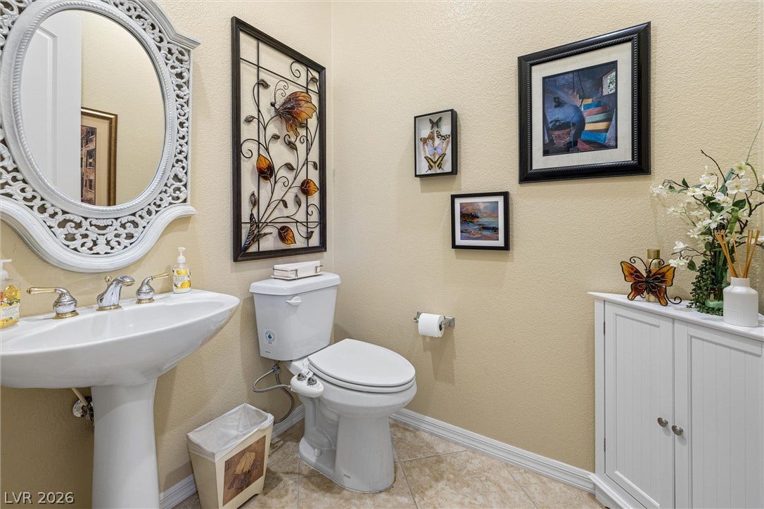 2107 Noah Tyler Ct., Henderson, NV 89052 A well-appointed powder room features classic tile flooring and a pedestal sink setup.