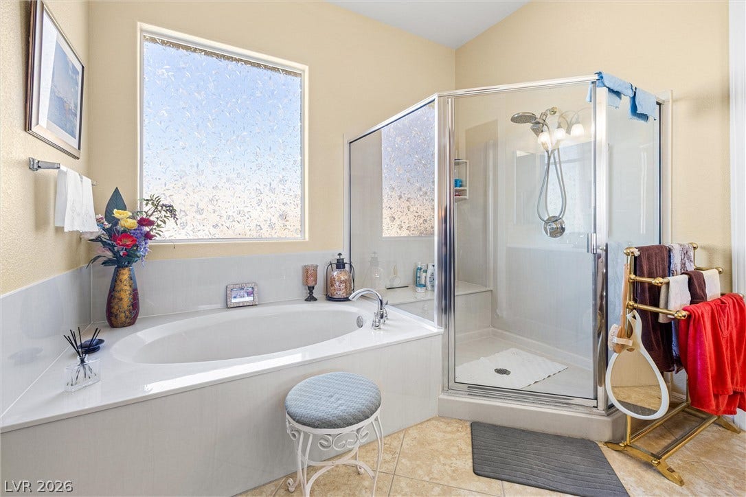 2107 Noah Tyler Ct., Henderson, NV 89052 A deep soaking tub sits adjacent to a separate glass-enclosed shower stall.